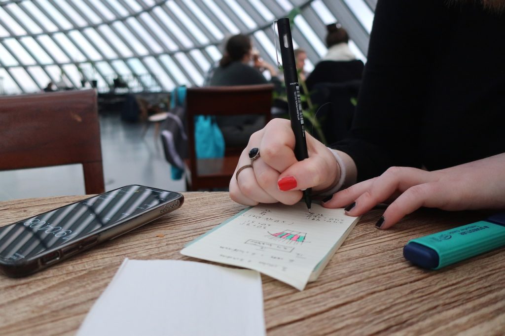 Женщина пишет и рисует на листке бумаги